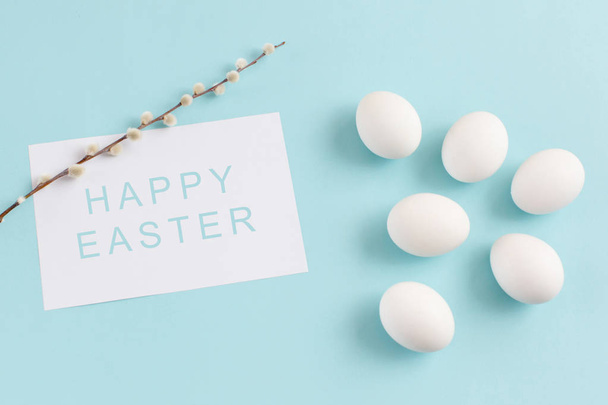 Decoración de Pascua, huevos blancos y ramita de sauce en una ba azul claro
 - Foto, imagen