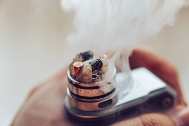 Man's hand holding Mod for vaping, vape device and dripping RDA without top cap - Photo, Image