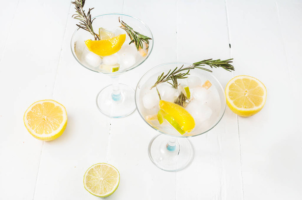 Джин, лимон, розмарин, коктейль с медом и свежими травами на белом фоне
 - Фото, изображение