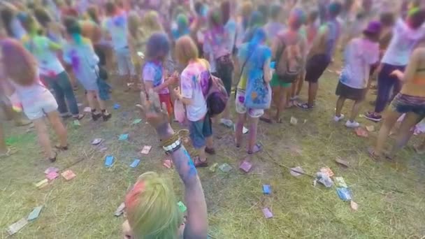 Mucha gente feliz cubierta de pintura colorida disfrutando del festival, bailando con música
 - Imágenes, Vídeo