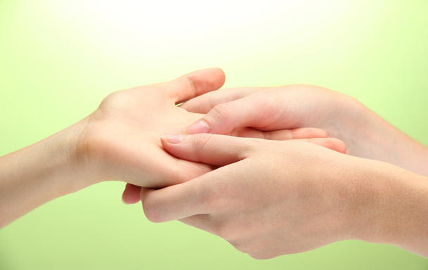 Hand massage, on green background - Foto, Imagen