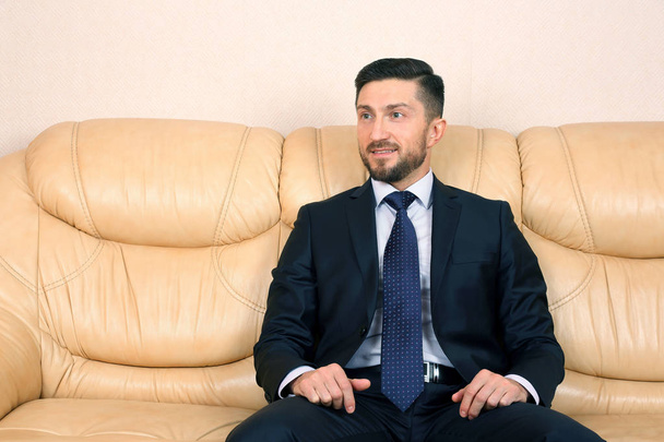 successful business man in suit sitting on leather sofa - Fotoğraf, Görsel