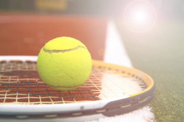 tennis ball and tennis racket on a tennis court with blurred background. - Photo, Image