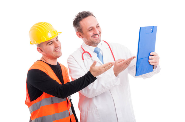 Lékař a konstruktor ukazuje něco na schránky a úsměv - Fotografie, Obrázek