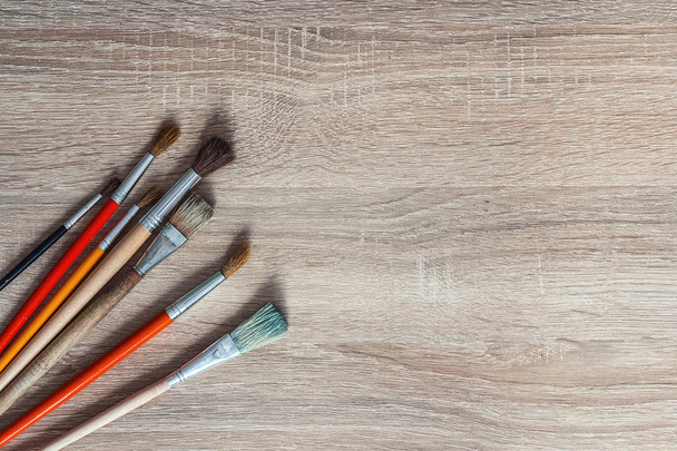 Several paintbrushes on a wooden background and empty space for  - Фото, зображення