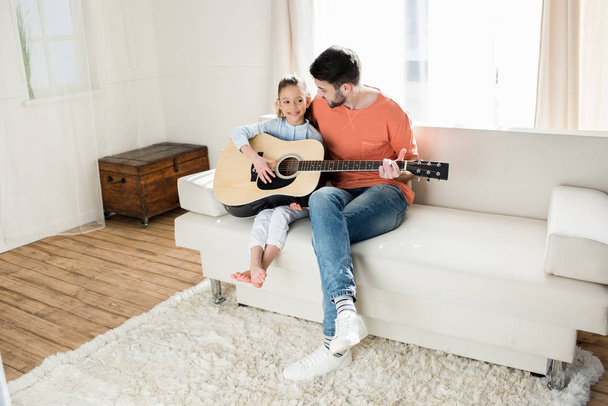 Father and daughter playing guitar - Fotó, kép