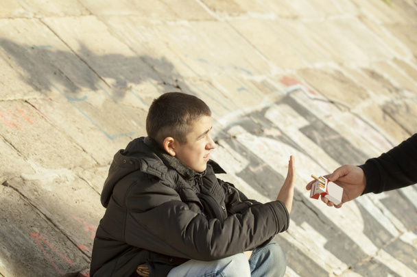 το αγόρι που αρνούνται κατηγορηματικά από τα προσφερόμενα τσιγάρα - Φωτογραφία, εικόνα