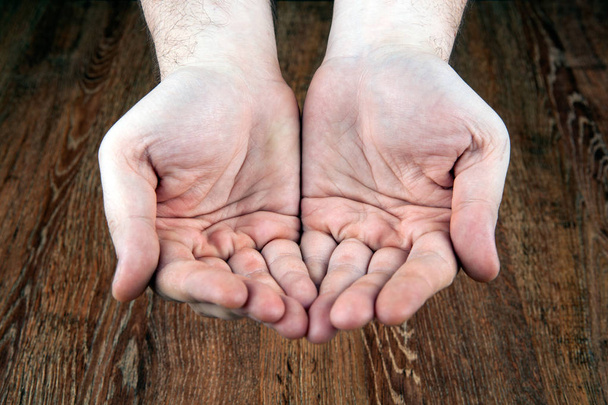 manos masculinas sobre un fondo de madera
 - Foto, Imagen