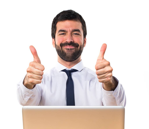 Businessman in his office with thumb up - Photo, image