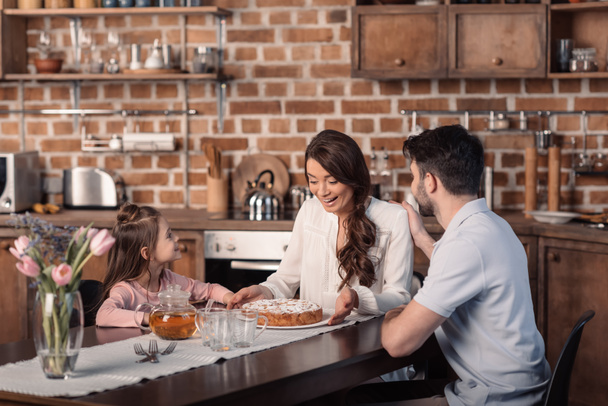family with cake in kitchen - Photo, Image