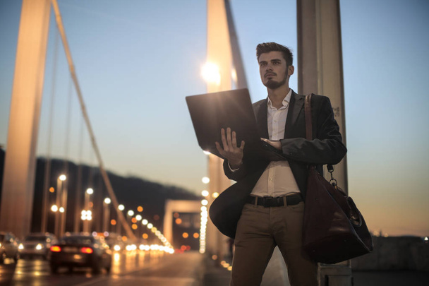 Young man with laptop on street - Φωτογραφία, εικόνα