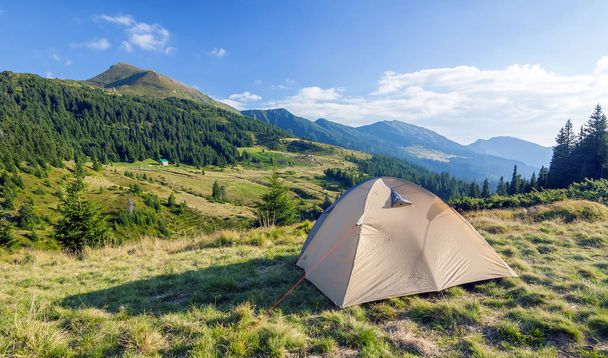 Tourist tent in mountains on a summer sunny day - 写真・画像