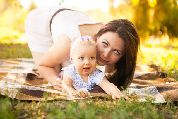 Feliz madre joven con el niño pasar tiempo al aire libre en un verano
  - Foto, Imagen
