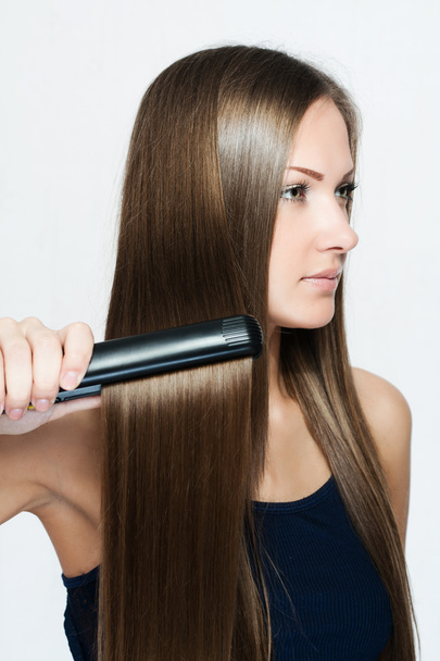 Beautiful woman hoding hair iron - Foto, Imagem