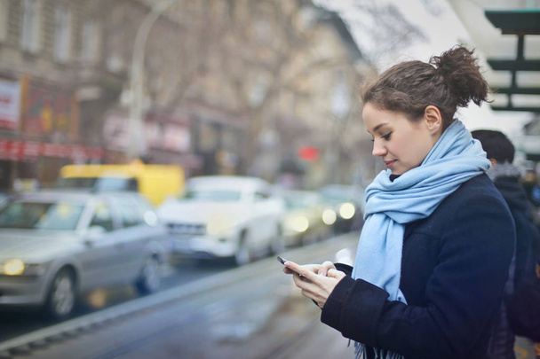 A woman is texting in the city - Photo, image