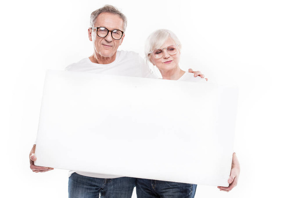 Senior beautiful couple with empty white board. - Foto, afbeelding
