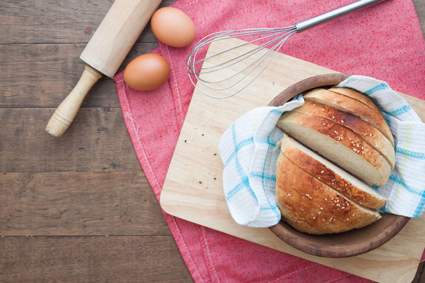 Zelfgebakken brood met eieren en keukengerei gesneden op hout backgr - Foto, afbeelding