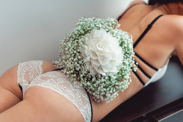 wedding bouquet of white gypsophila and hydrangea on the naked bride back - Foto, afbeelding