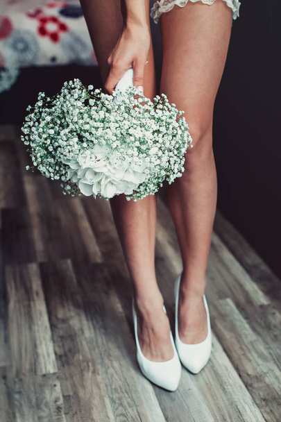 wedding bouquet of white gypsophila and hydrangea in a hand of naked bride - Foto, immagini