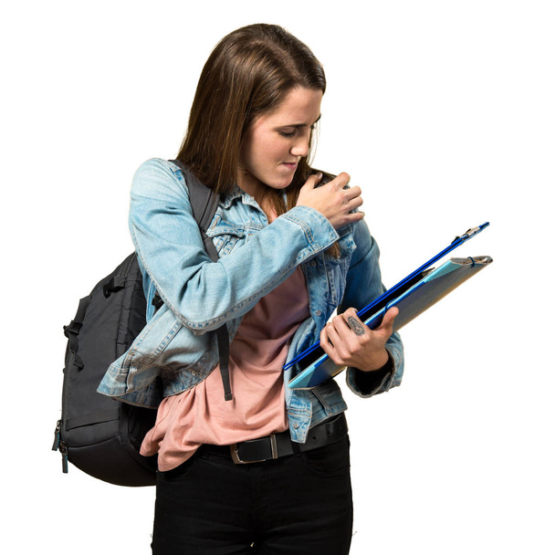 Teen student girl holding books and with shoulder pain - Photo, Image