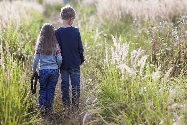 Маленький мальчик и маленькая девочка стоят, держась за руки, глядя на Хор
 - Фото, изображение