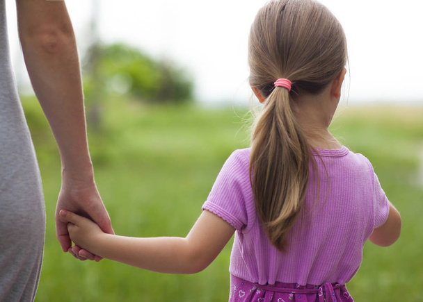 Маленька дівчинка тримає руку своєї матері. Сімейні відносини
 - Фото, зображення