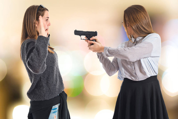 Tiener meisje wijzen met een pistool - Foto, afbeelding