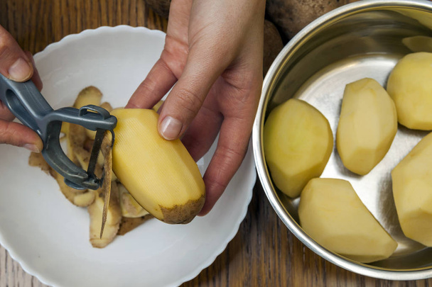 Mutfak p ile taze sarı patates soyma kadın detay eller - Fotoğraf, Görsel