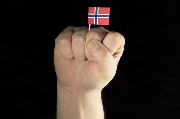 Mann Faust mit norwegischer Flagge isoliert auf schwarzem Hintergrund - Foto, Bild