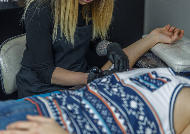 Ξανθιά καλλιτέχνης που κάνει ένα τατουάζ - Φωτογραφία, εικόνα