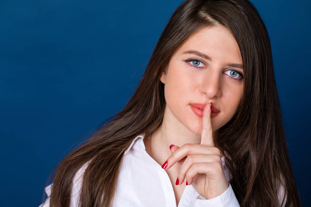 Beautiful brunette woman has put forefinger to lips as sign of s - Φωτογραφία, εικόνα