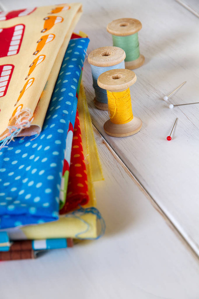 Colorful fabrics with pins, measuring tape and rolling cotton - Фото, зображення