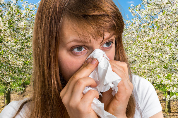 Woman with allergy near flowering trees - Photo, Image