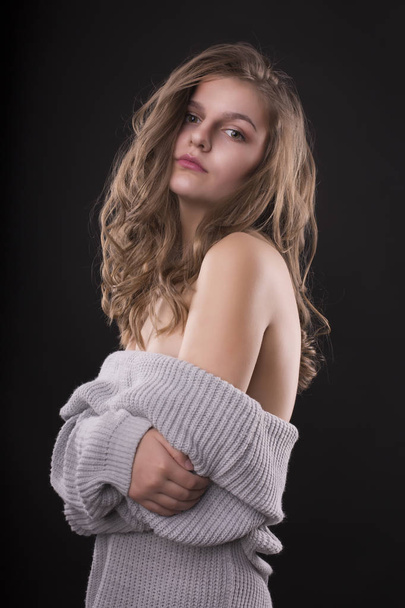 Seductive young woman posing in sweater with naked shoulders - Fotoğraf, Görsel