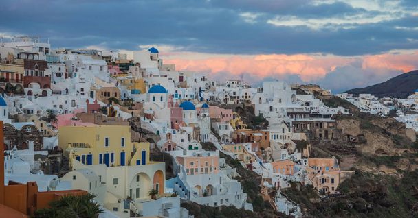 White city on a slope of a hill at sunset, Oia, Santorini, Greec - Foto, immagini