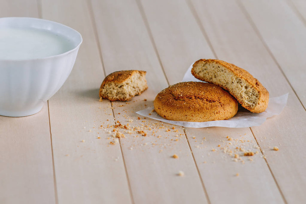 De délicieux biscuits frais sur une table en bois. Près du cookie est tasse blanche avec du yaourt
.  - Photo, image