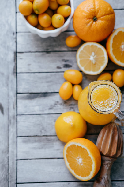 Vertical photo with Kumquat in a white bowl, oranges, lemons and - Φωτογραφία, εικόνα