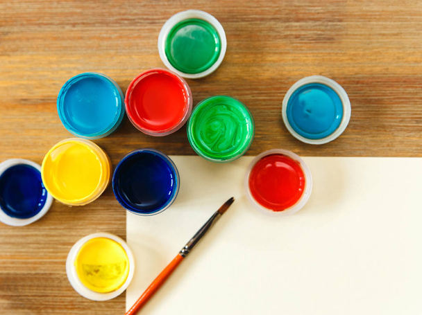 latas de colores con pintura, pincel y table.wooden table.top ver
. - Foto, Imagen