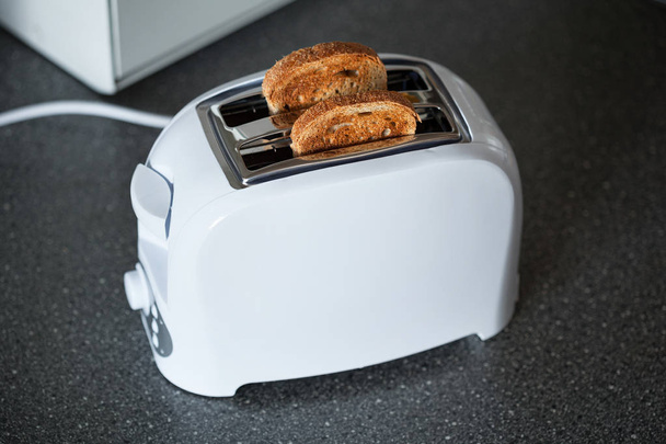 Tost makinesiyle mutfakta ekmek dilimleri - Fotoğraf, Görsel