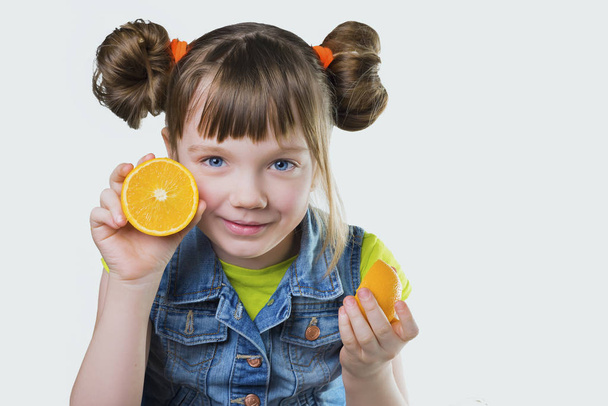 Baby girl blessed with a smile and an orange in the hands - 写真・画像