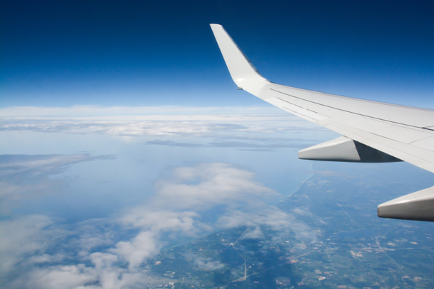 Крыло самолета над голубым небом
 - Фото, изображение