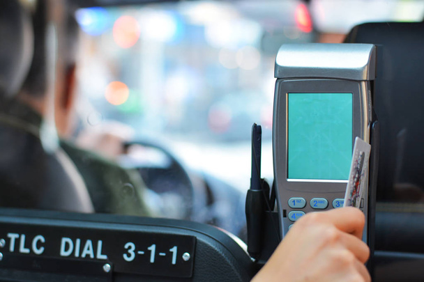 Primer plano de una mano pagando un viaje en taxi con tarjeta de crédito
 - Foto, imagen