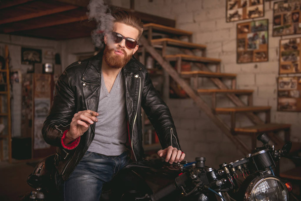 Guy in motorbike repair shop - Foto, imagen