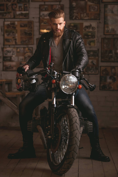 Guy in motorbike repair shop - Foto, afbeelding