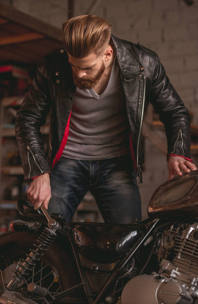 Guy in motorbike repair shop - Zdjęcie, obraz