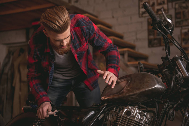 Guy in motorbike repair shop - Fotoğraf, Görsel