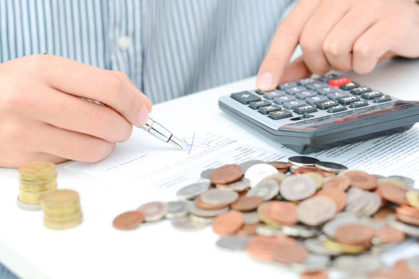 Calcul d'impôt ou nouveau contrat de prêt avec calculatrice manuelle et pièces
 - Photo, image