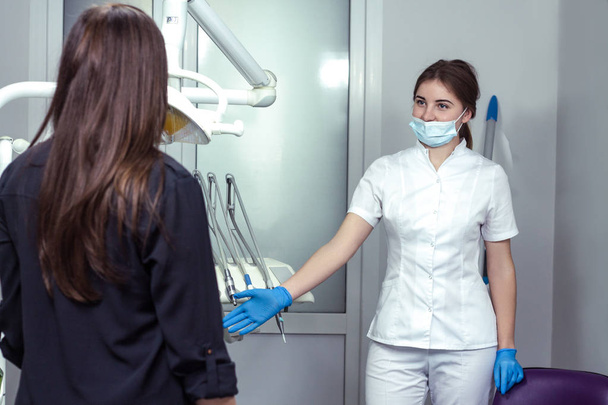 молодая женщина-дантист приветствует пациентку
  - Фото, изображение