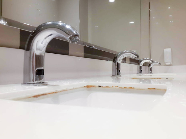 many steel taps in white ceramic sink - Photo, Image