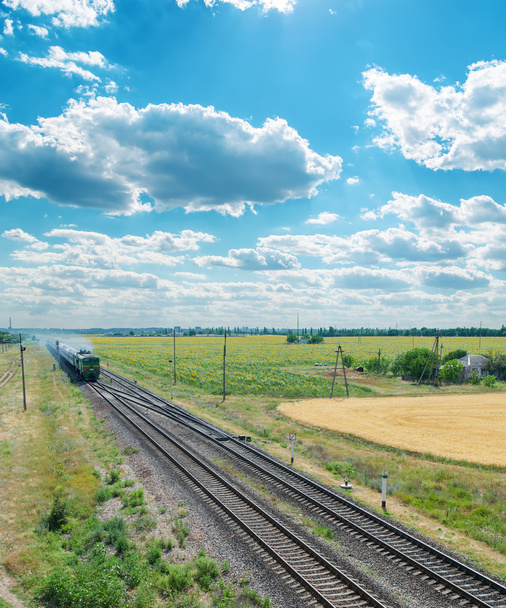 railroad with train under cloudy sky - Фото, изображение